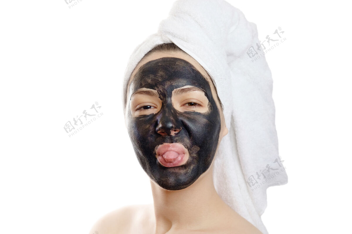健康特写镜头：白脸上戴着黑面具的美女 头上戴着白毛巾的女孩化妆品女人清洁