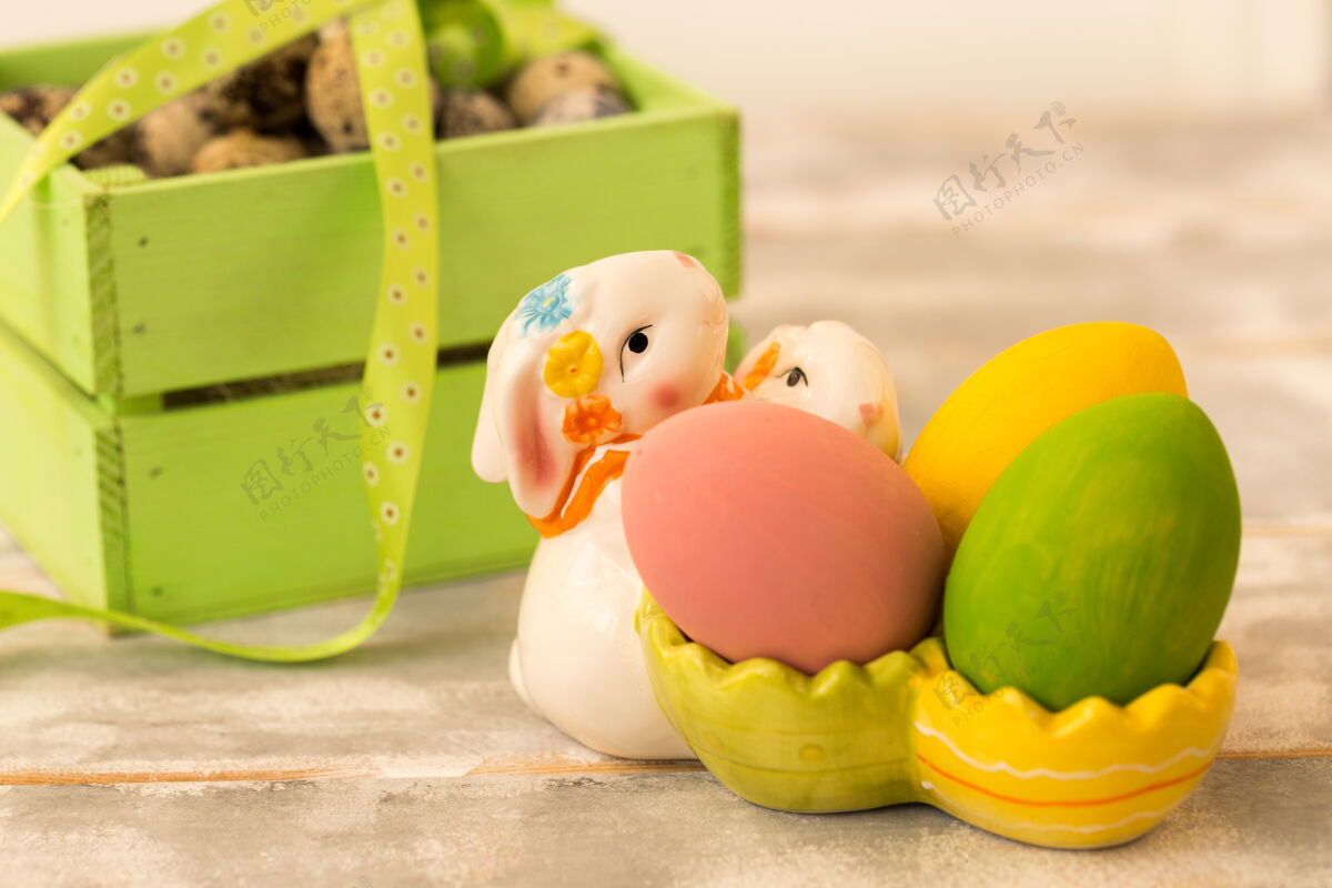 兔子五彩缤纷的复活节彩蛋放在木箱里 兔子 彩带放在木箱上食物兔子复活节