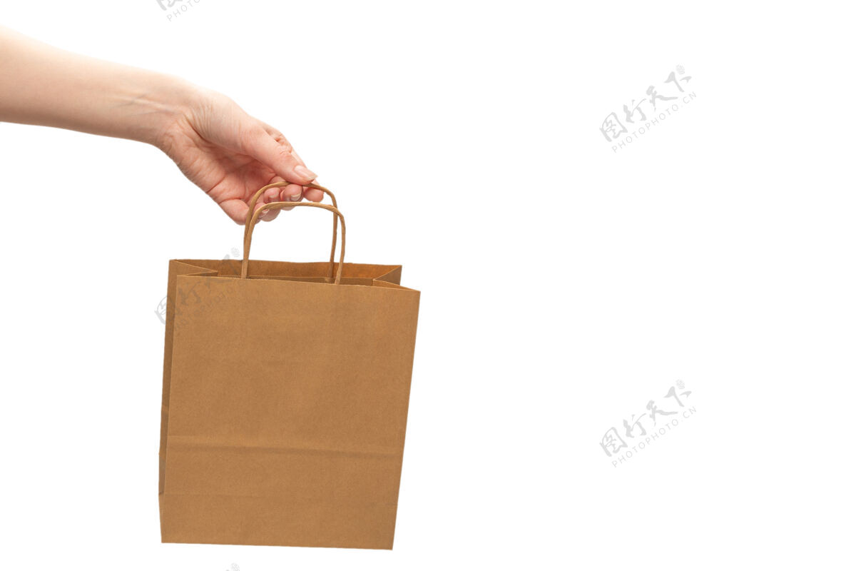 商店纸袋在女人的手上隔离在白色的背景上工艺销售持有