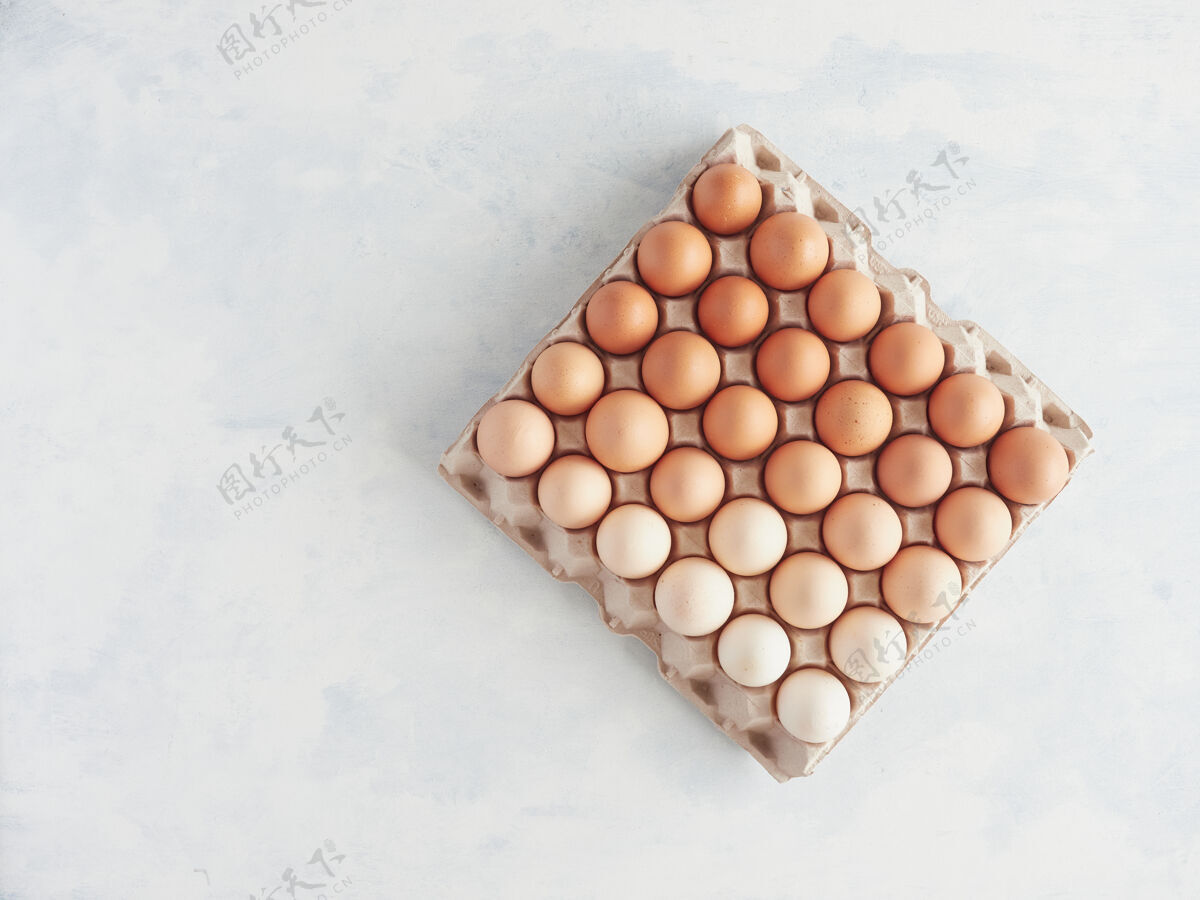 集装箱纸箱鸡蛋盒与许多棕色鸡蛋在不同的颜色和降解色调俯视图平铺纸板鸡蛋纸箱