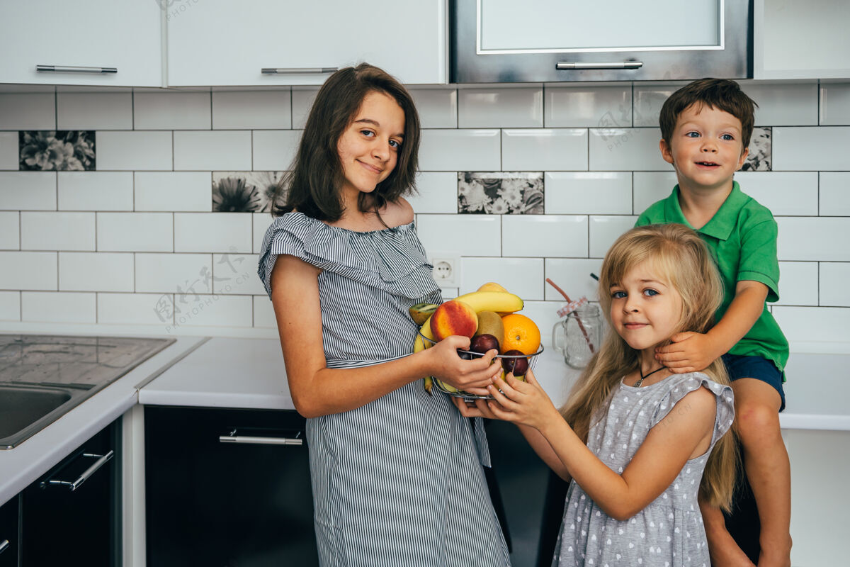 人健康的概念吃有趣孩子们在厨房里吃水果孩子水果女孩