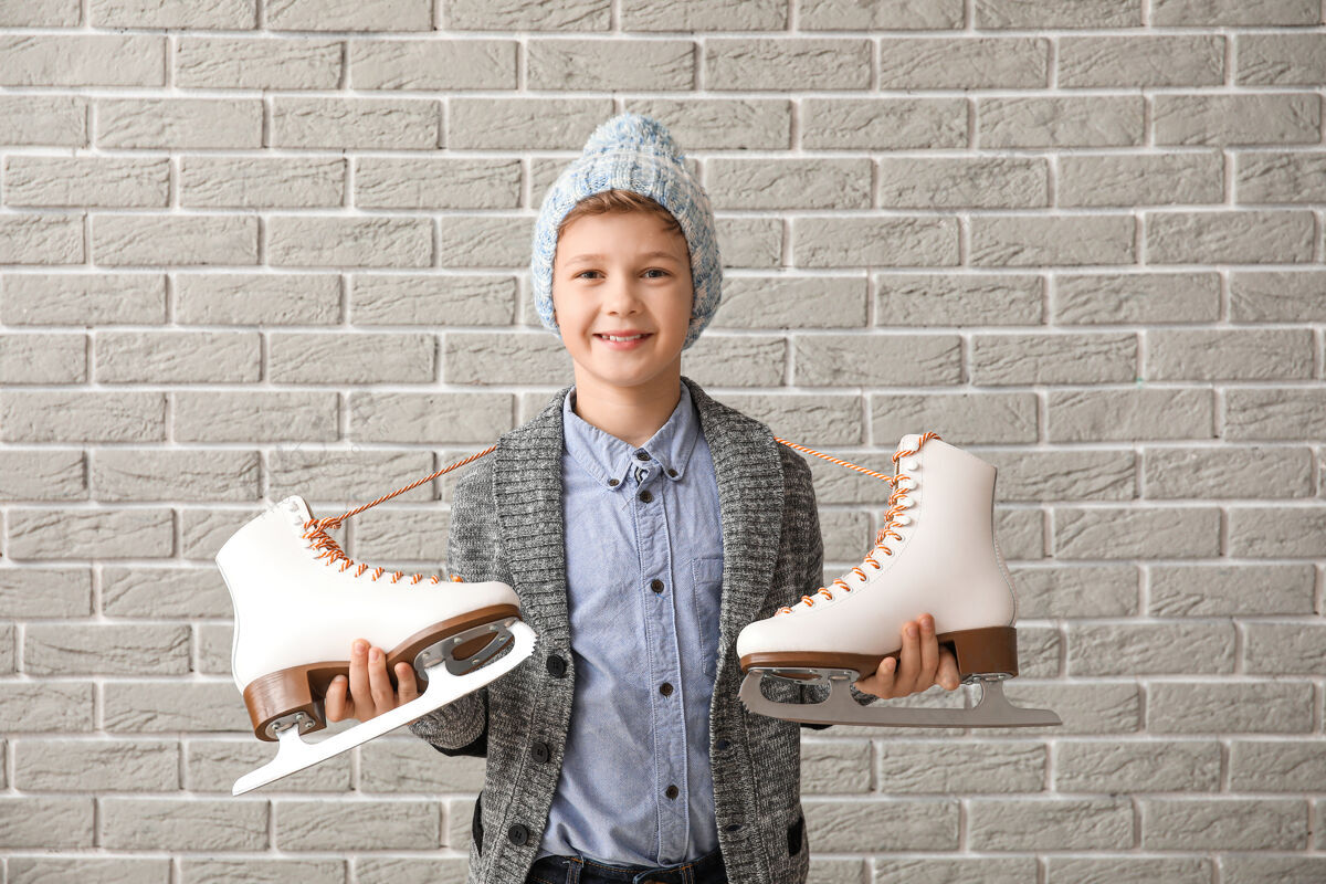 鞋可爱的小男孩用冰鞋抵着砖头溜冰可爱鞋子