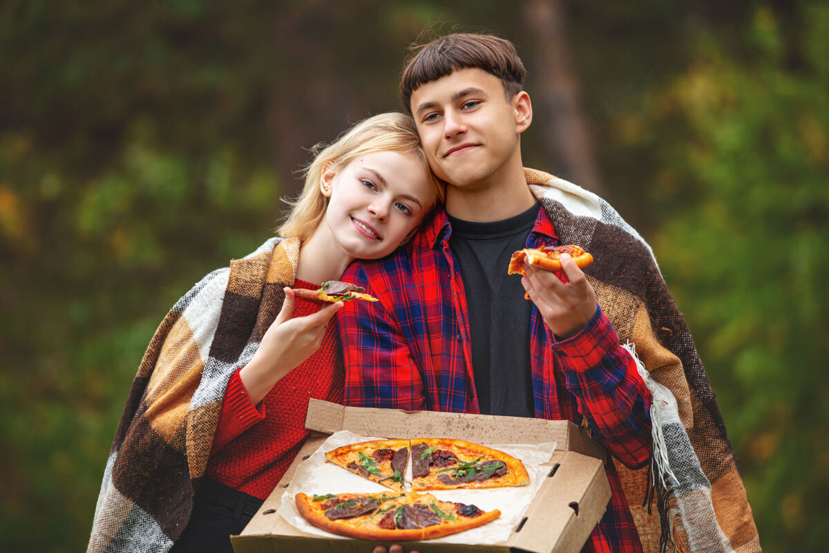 关系一对年轻有趣美丽的男女一起享受披萨和社交野餐美食学生朋友