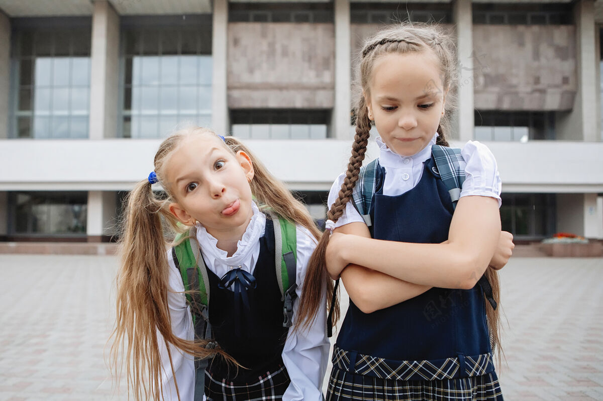 高尔夫两个穿着制服 梳着马尾辫的十几岁的女学生在镜头前摆姿势 做鬼脸裙子朋友小学生