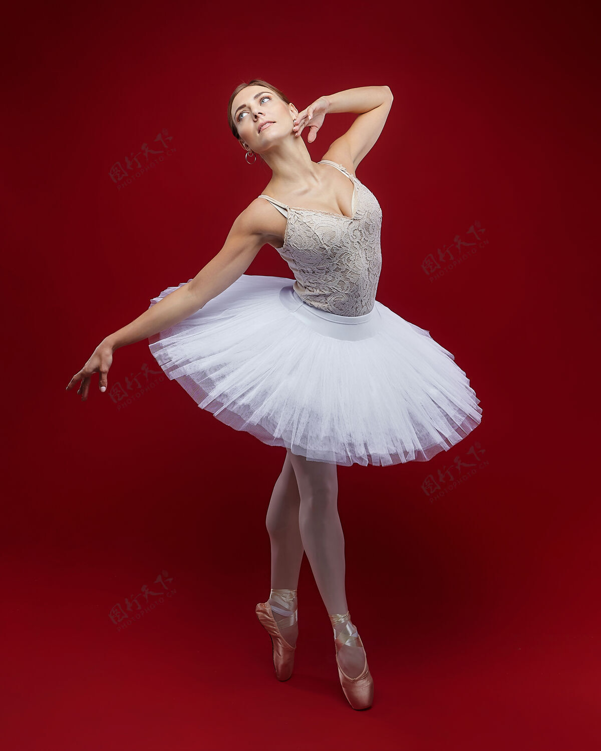 漂亮迷人的芭蕾舞演员在红色背景上优雅地摆出姿势芭蕾腿美女