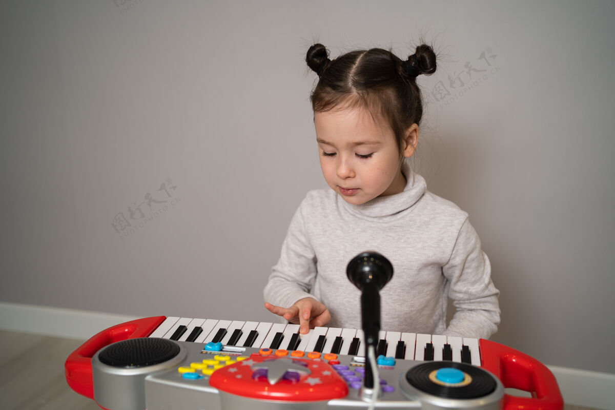 女性有创造力的孩子玩游戏合成器小学习弹钢琴的女孩一起牛仔幼儿园