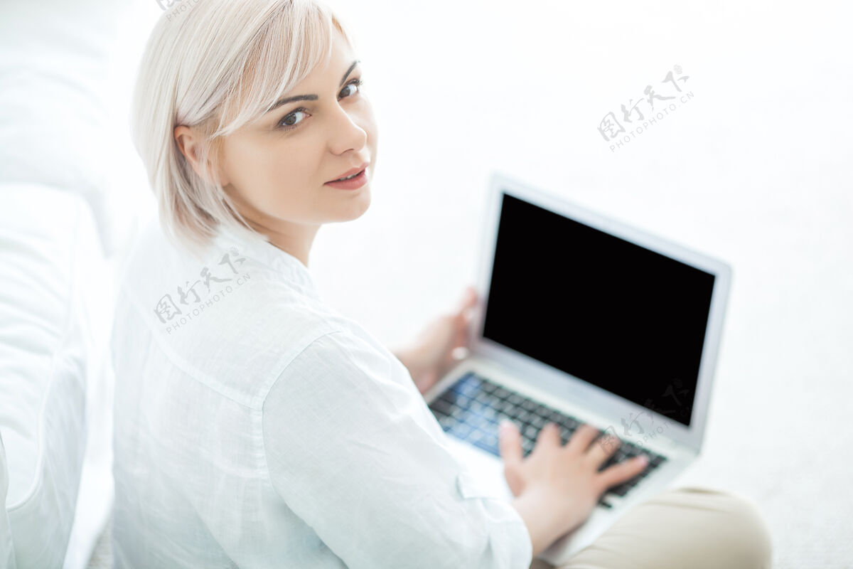 时尚中年妇女在笔记本电脑上打字室内女性浏览电脑舒适成人