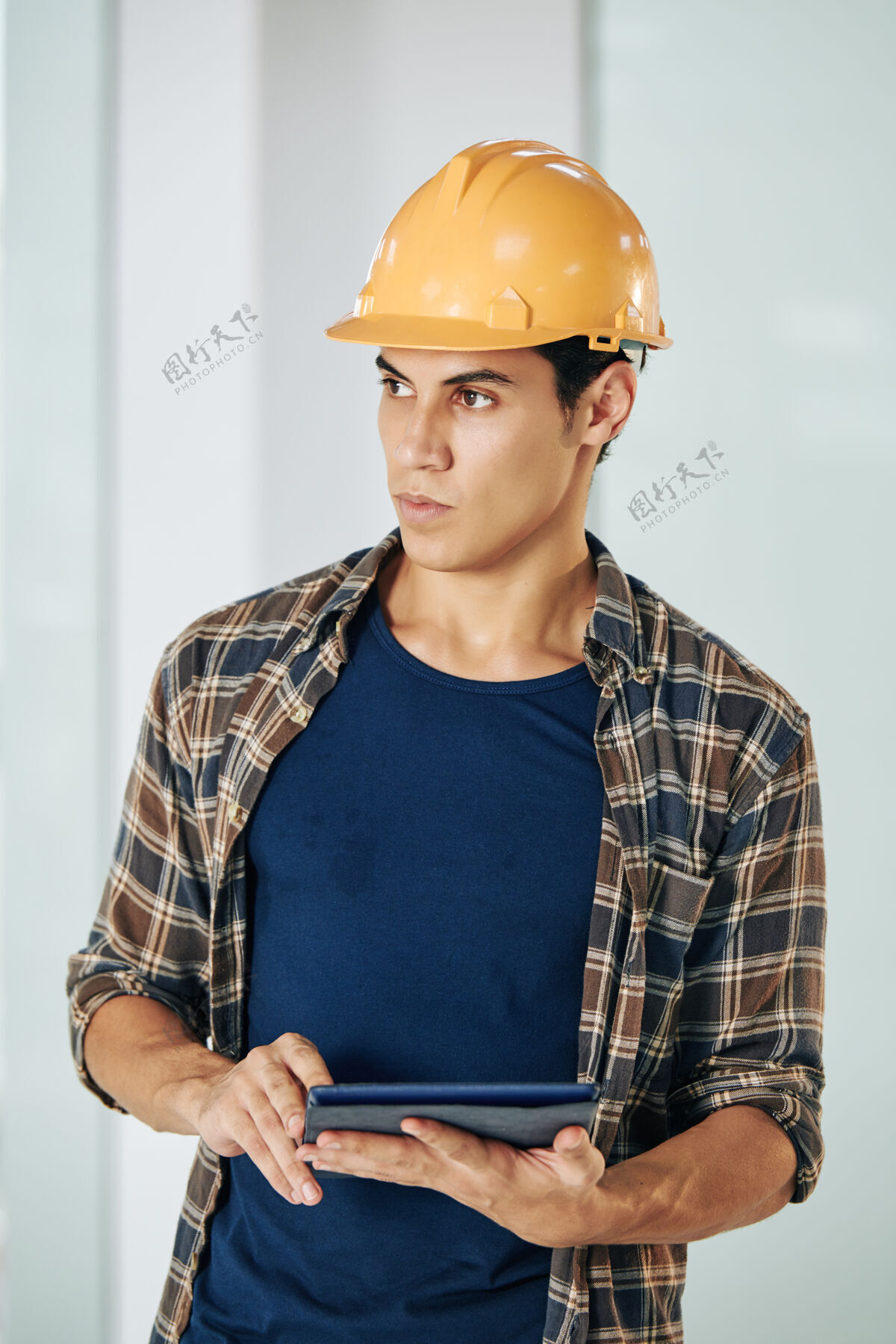 工程师一幅严肃的年轻土木工程师的画像 手里拿着数字平板电脑 望着远方承包商修理工修理工