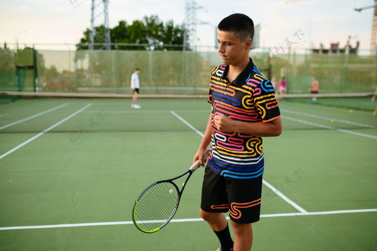 年轻以男子网球运动员为中心 带球拍 户外训练court.活动健康的生活方式 人们玩体育游戏 健身锻炼与球拍活动人网