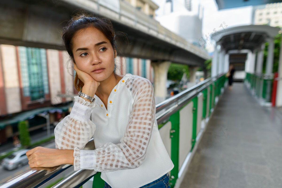 思考年轻美丽的亚洲女商人在城市户外天空火车站的画像公共行政人员不开心