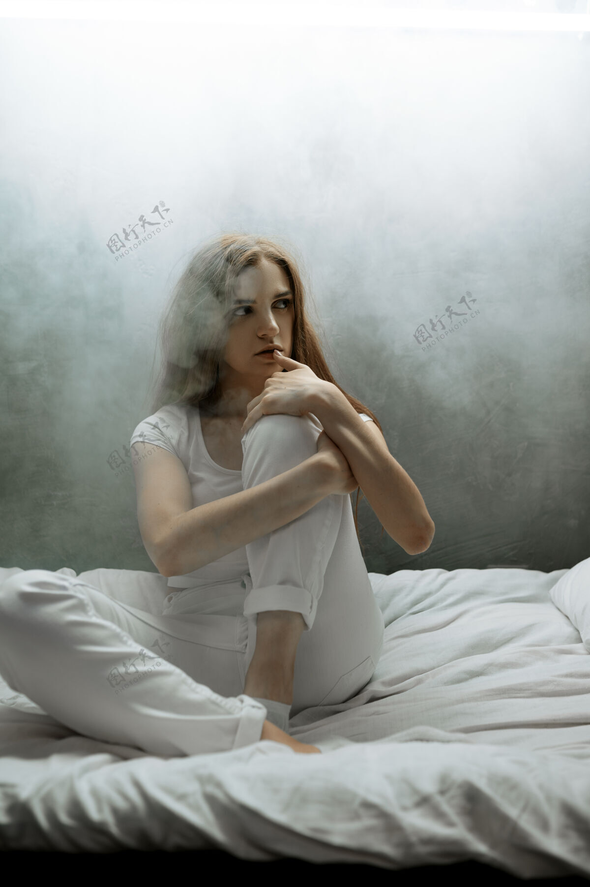 医院一个带枕头的疯女人坐在床上 黑乎乎的房间迷幻药每晚都有问题的人 抑郁和压力 悲伤 精神病院夜晚人肖像