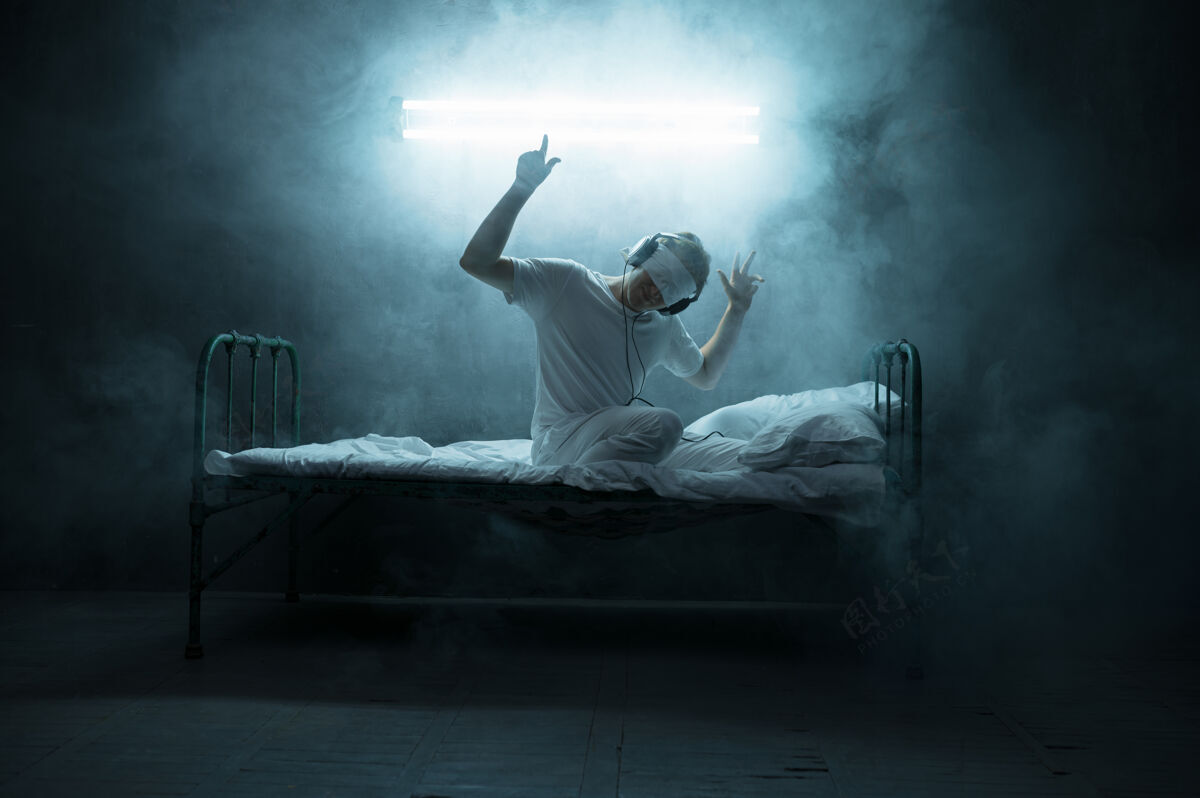 神秘蒙住眼睛坐在床上的精神病男人 失眠恐怖 黑暗的房间…迷幻的男人每晚都有问题 抑郁和压力 悲伤 精神病医院生病悲伤夜