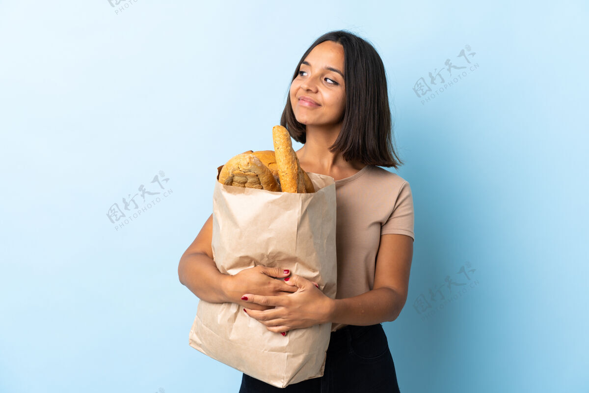 忽略一个年轻的拉丁女人在买面包时 一边看一边有疑虑比赛问题女性