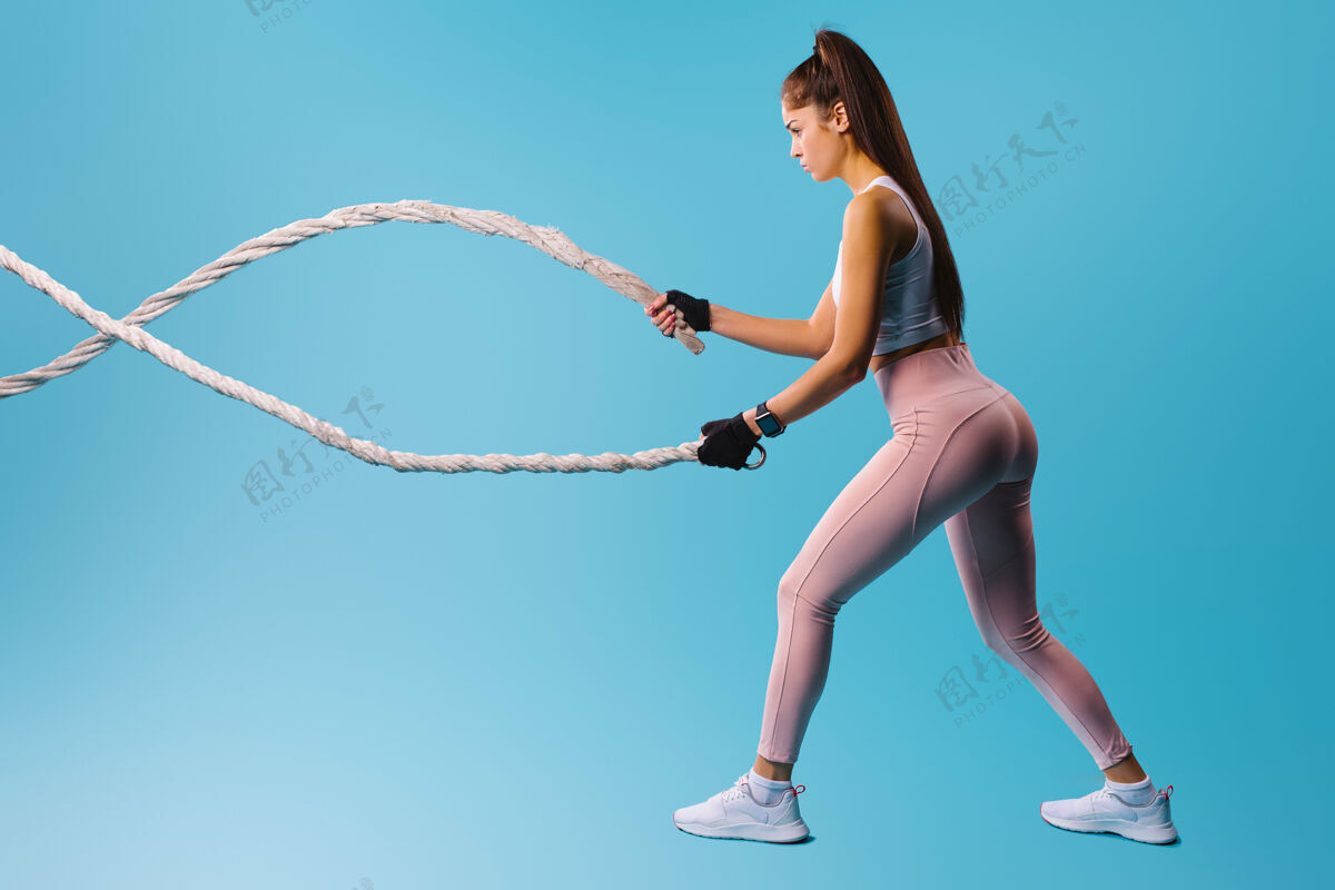 锻炼穿蓝色运动服的运动女孩背景.运动健康的生活方式理念健身房绳索时尚模特