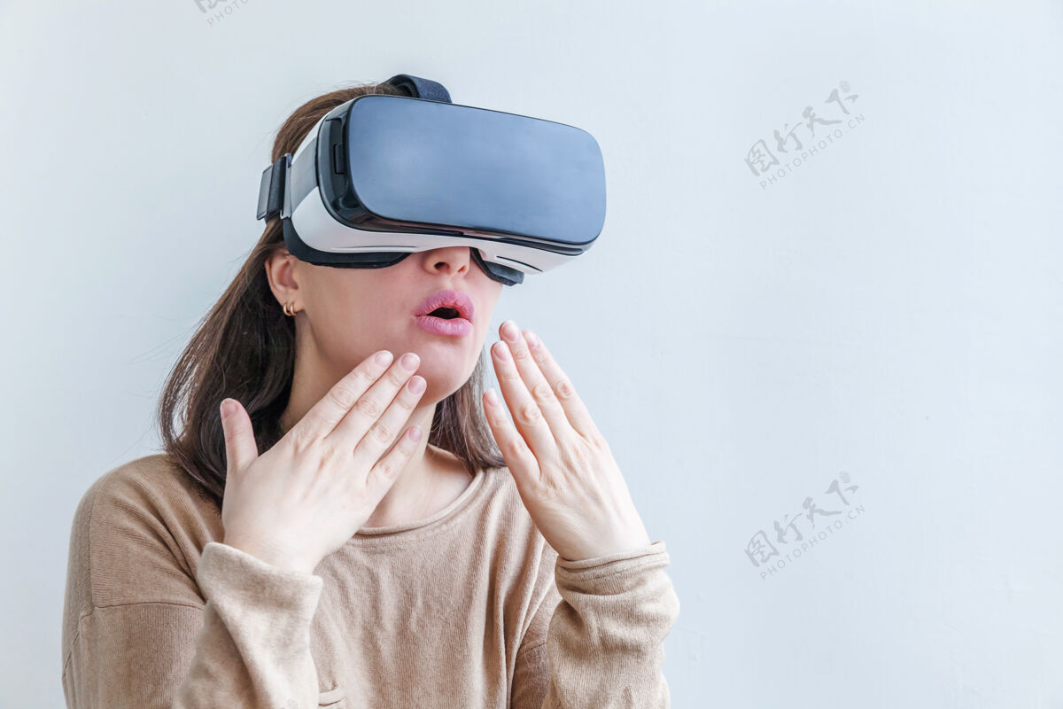 虚拟微笑的年轻女子戴着虚拟现实vr眼镜头盔耳机在白色背景上游戏未来视觉