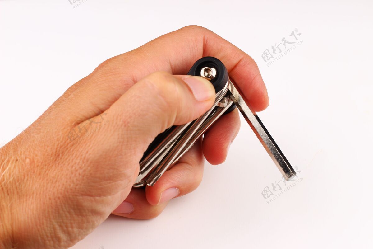 螺丝自行车钥匙在手上的白色表面特写修理扳手车轮