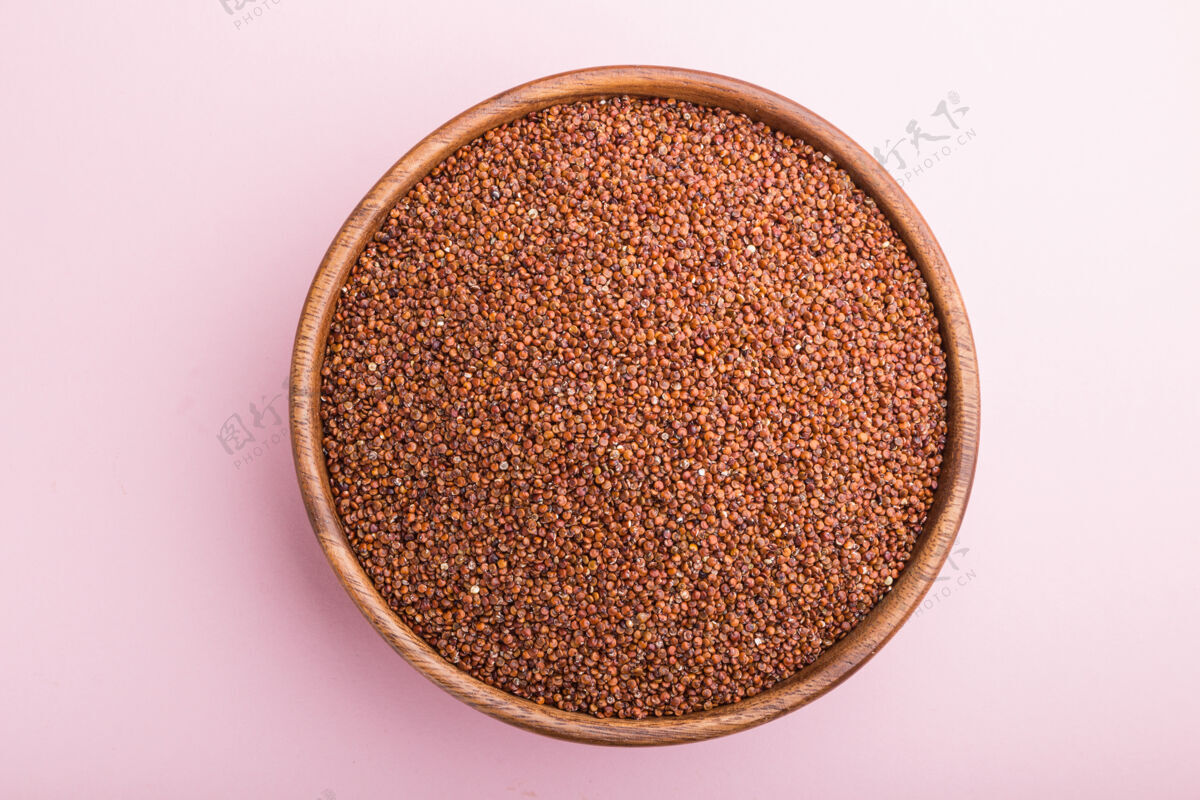 谷物木碗与生的红色奎奴亚藜种子粉彩表面葡萄酒木头干