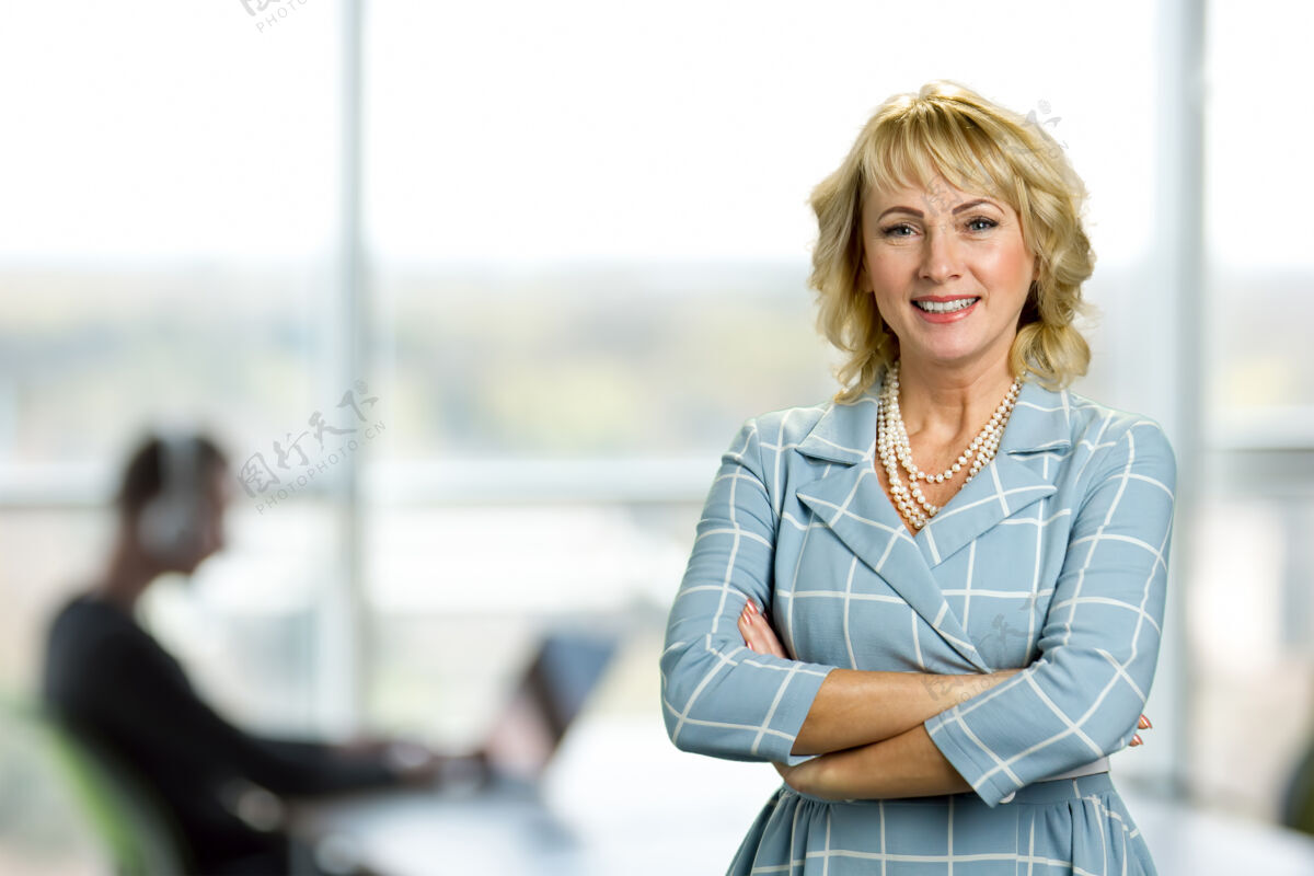 个人双臂交叉的成熟女人办公室里快乐的双手交叉的白皮女人的画像快乐专业心理学