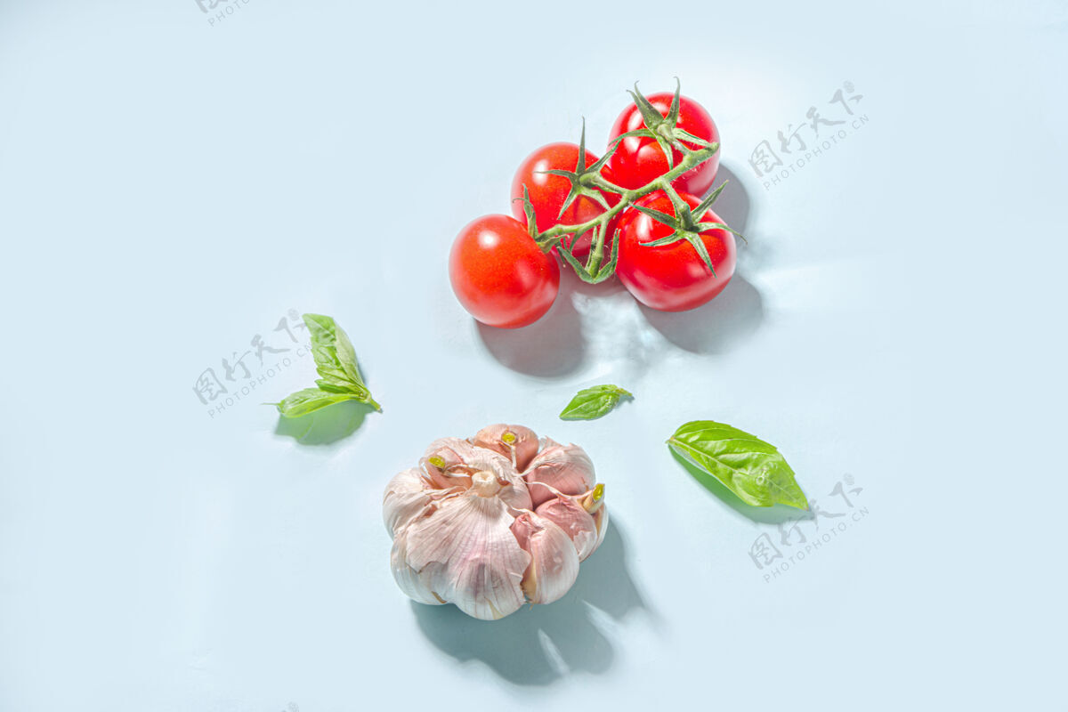 高级地中海美食烹饪背景 新鲜西红柿 罗勒 橄榄油和大蒜的蓝色背景素食橄榄扁平
