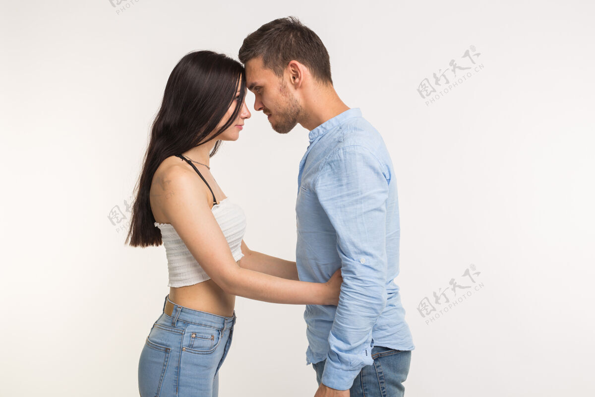 爱关系问题的概念-愤怒的年轻女子拥抱她的丈夫在白色的表面愤怒20多岁冒犯