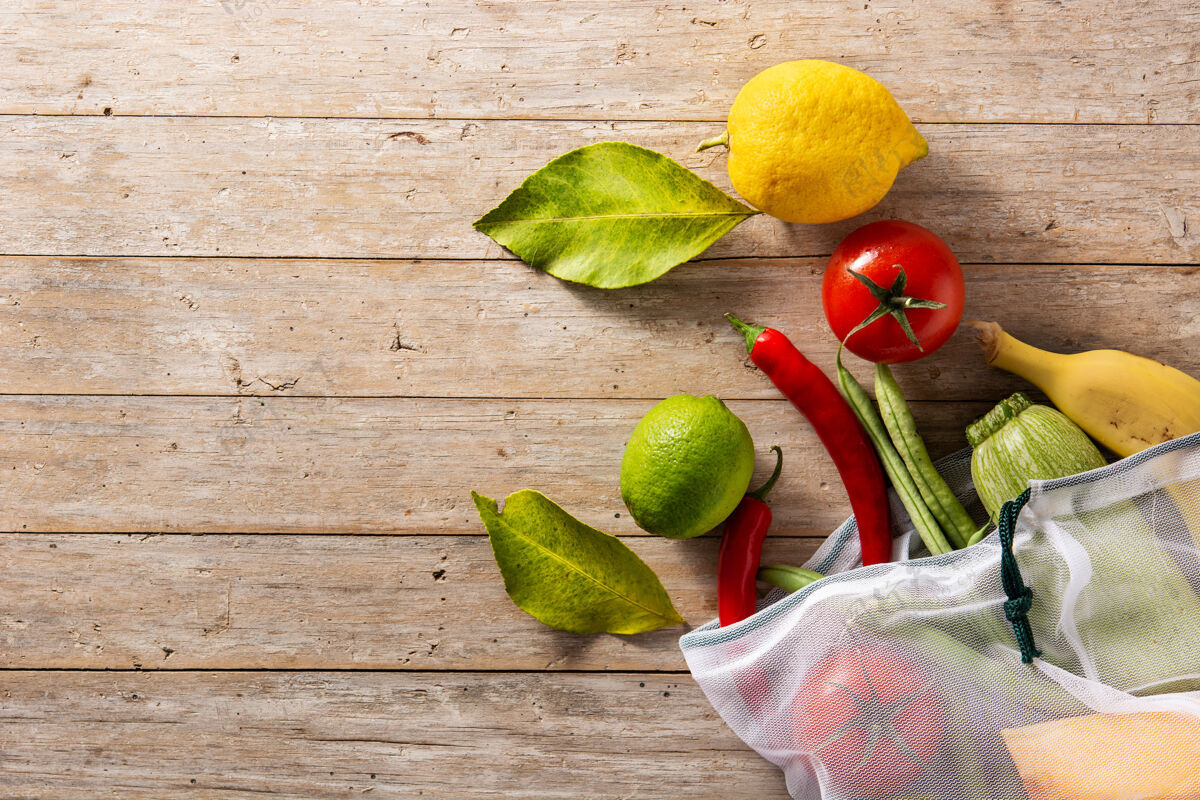 蔬菜环保的可重复使用的购物袋与蔬菜和水果在木桌上蔬菜营养生态