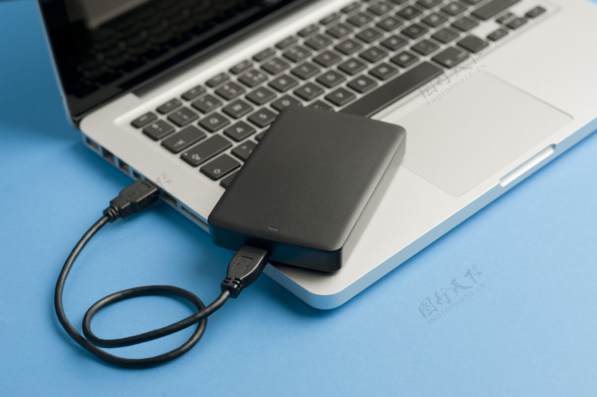 桌面笔记本电脑蓝色桌上带黑色电缆usb的外部硬盘屏幕笔记本电脑电脑