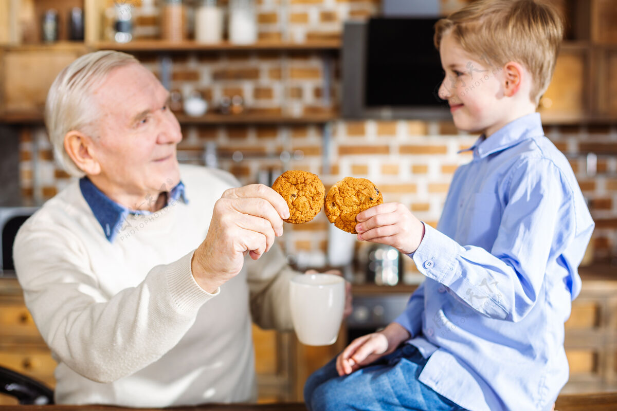 甜点可爱的小男孩在家休息时和爷爷一起吃自制糕点爸爸享受爷爷