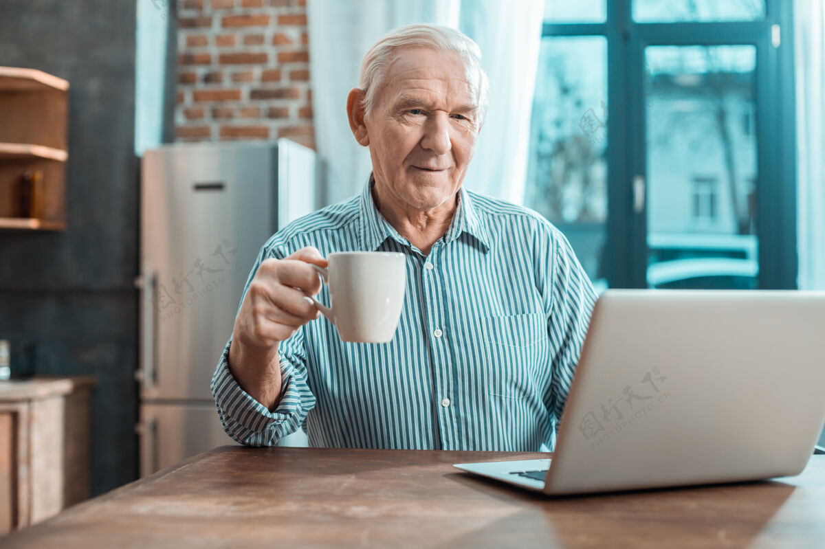 人很好的放松老人在家休息时喝茶看笔记本电脑屏幕互联网快乐社会