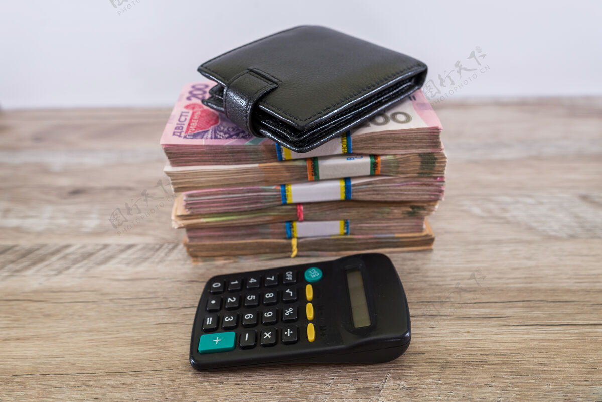 许多一捆格里夫尼亚 桌上有计算器和钱包账单利润商业