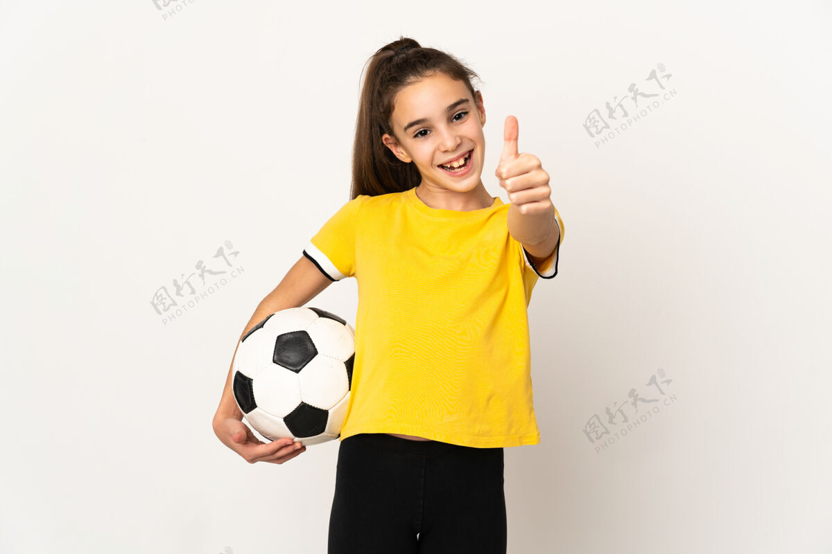 孩子因为发生了好事 一个小足球运动员女人被隔离在白墙上 竖起大拇指足球女孩运动员