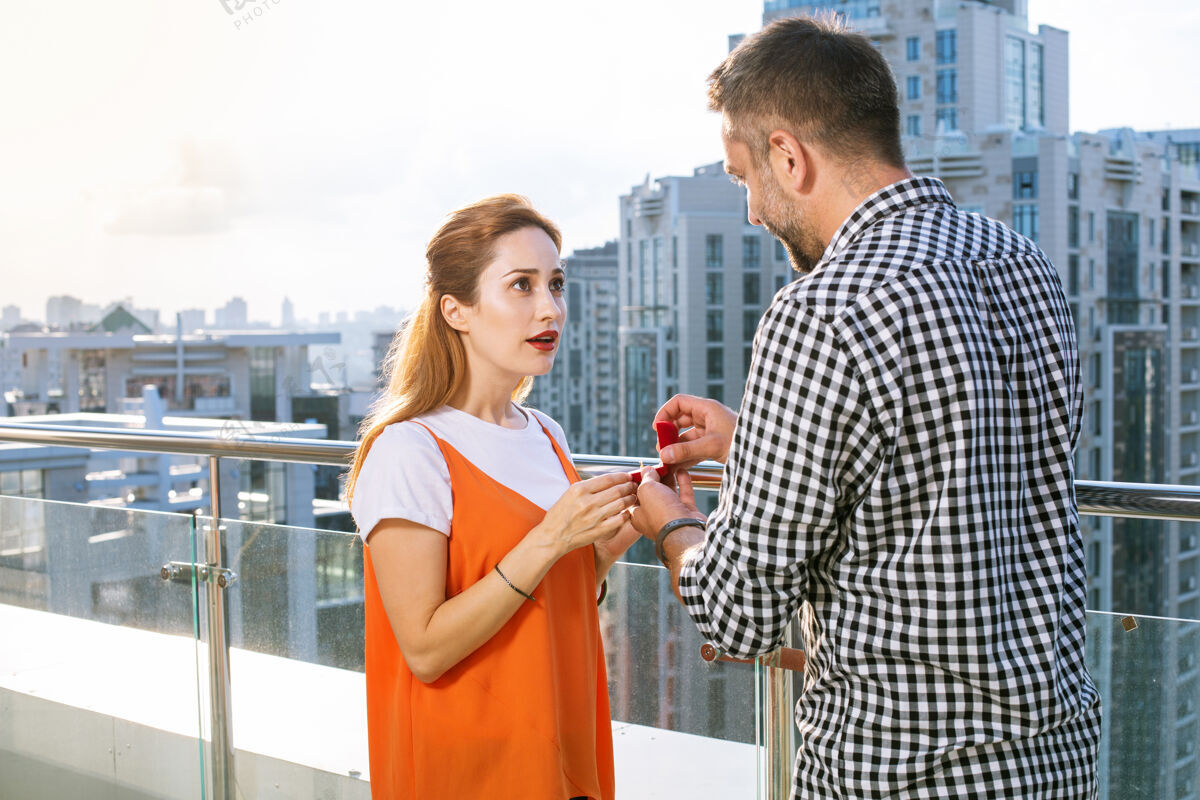 感情浪漫事件漂亮漂亮的女人看着她的男朋友 同时得到他的求婚关系欢乐求婚