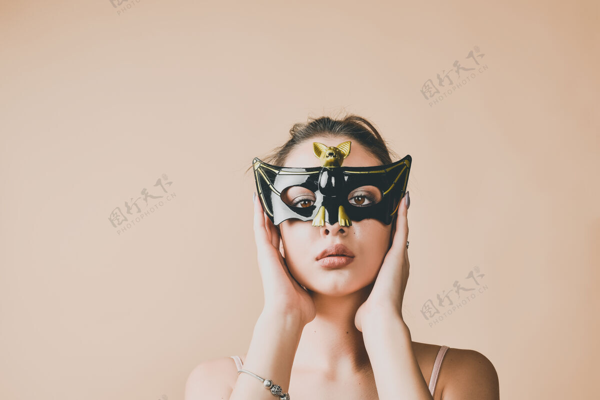 女人戴蝙蝠面具参加化妆舞会或万圣节派对的年轻女子服装人万圣节