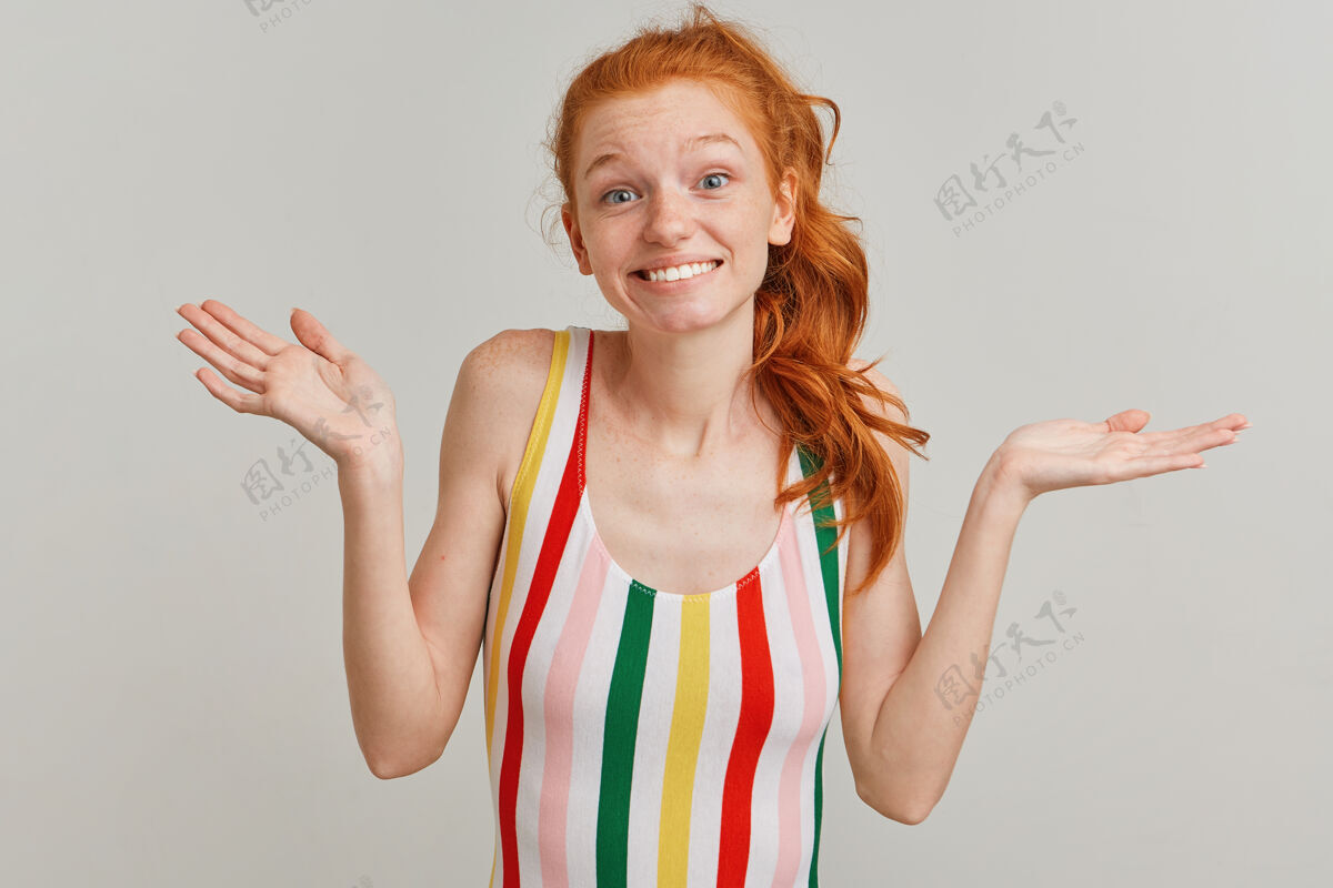 微笑年轻的女士 漂亮的女人 姜黄色的马尾和雀斑 穿着条纹彩色泳衣美丽生姜红发