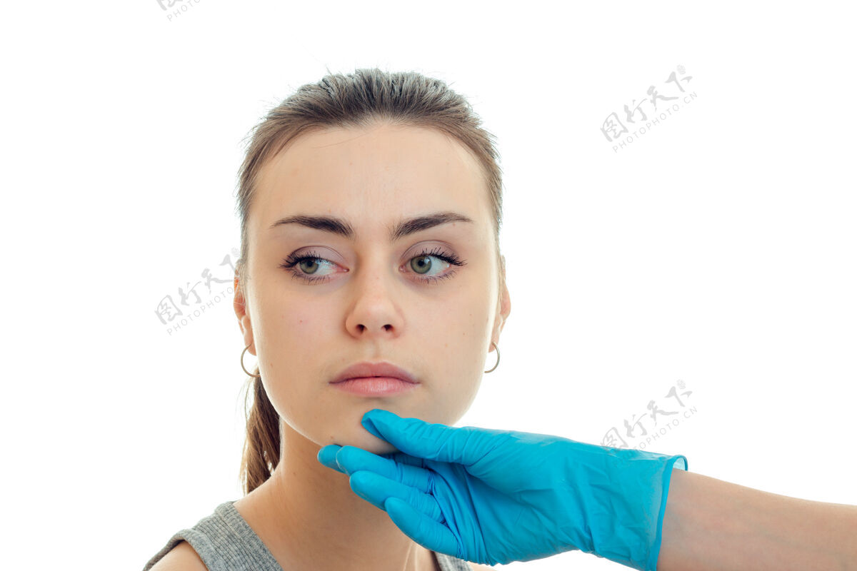 手年轻漂亮的女人在整形外科隔离在白墙上皱纹皮肤护理注射