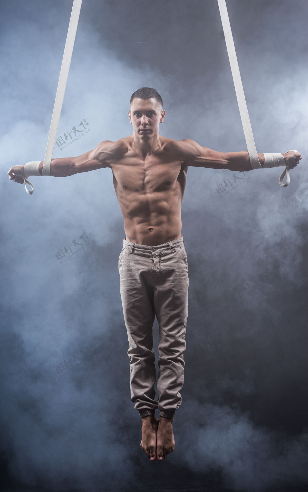 肌肉马戏团艺术家在空中肩带与强大的肌肉黑色平衡动作腰带
