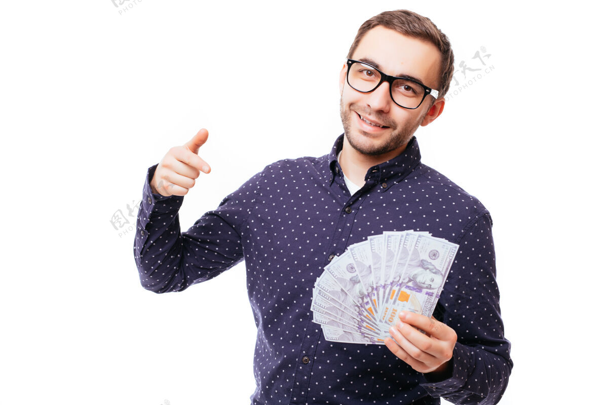 美元一个严肃自信的男人拿着一捆钞票 手指着隔着白墙的正面手休闲手指