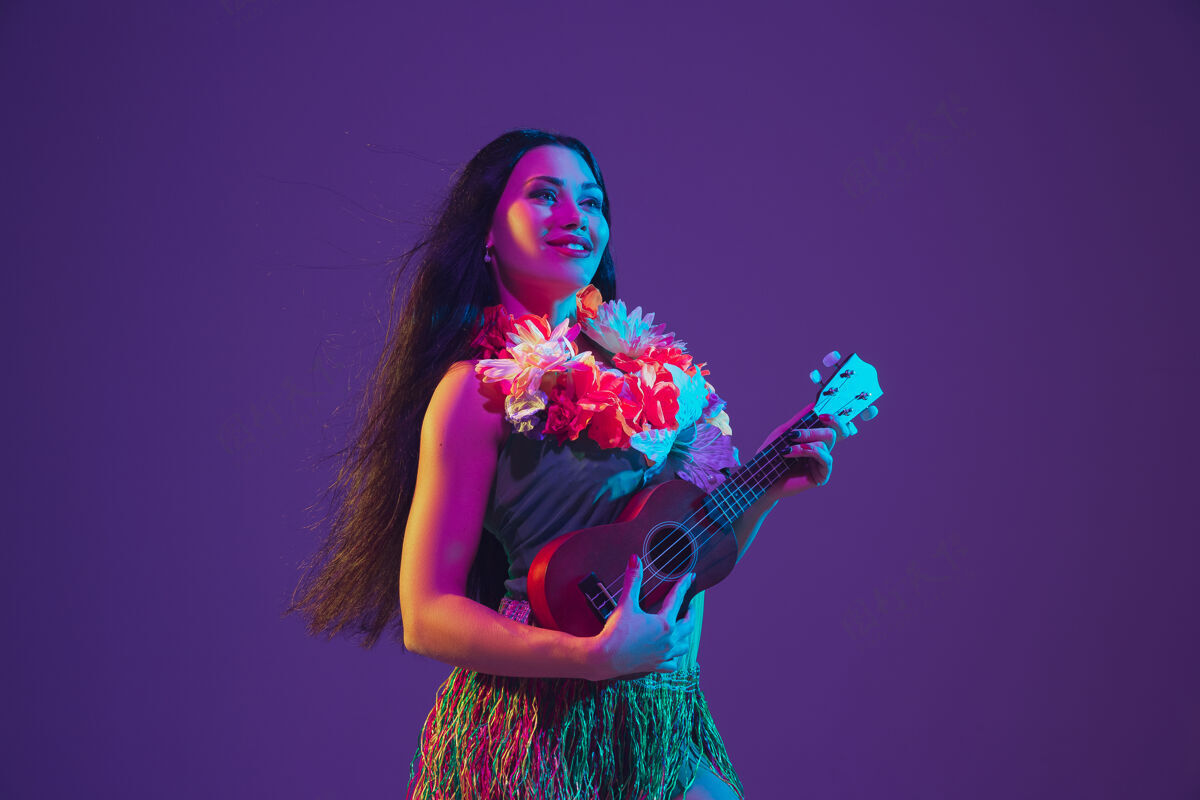 紫色紫色墙壁霓虹灯上的夏威夷女舞者霓虹灯庆典服装
