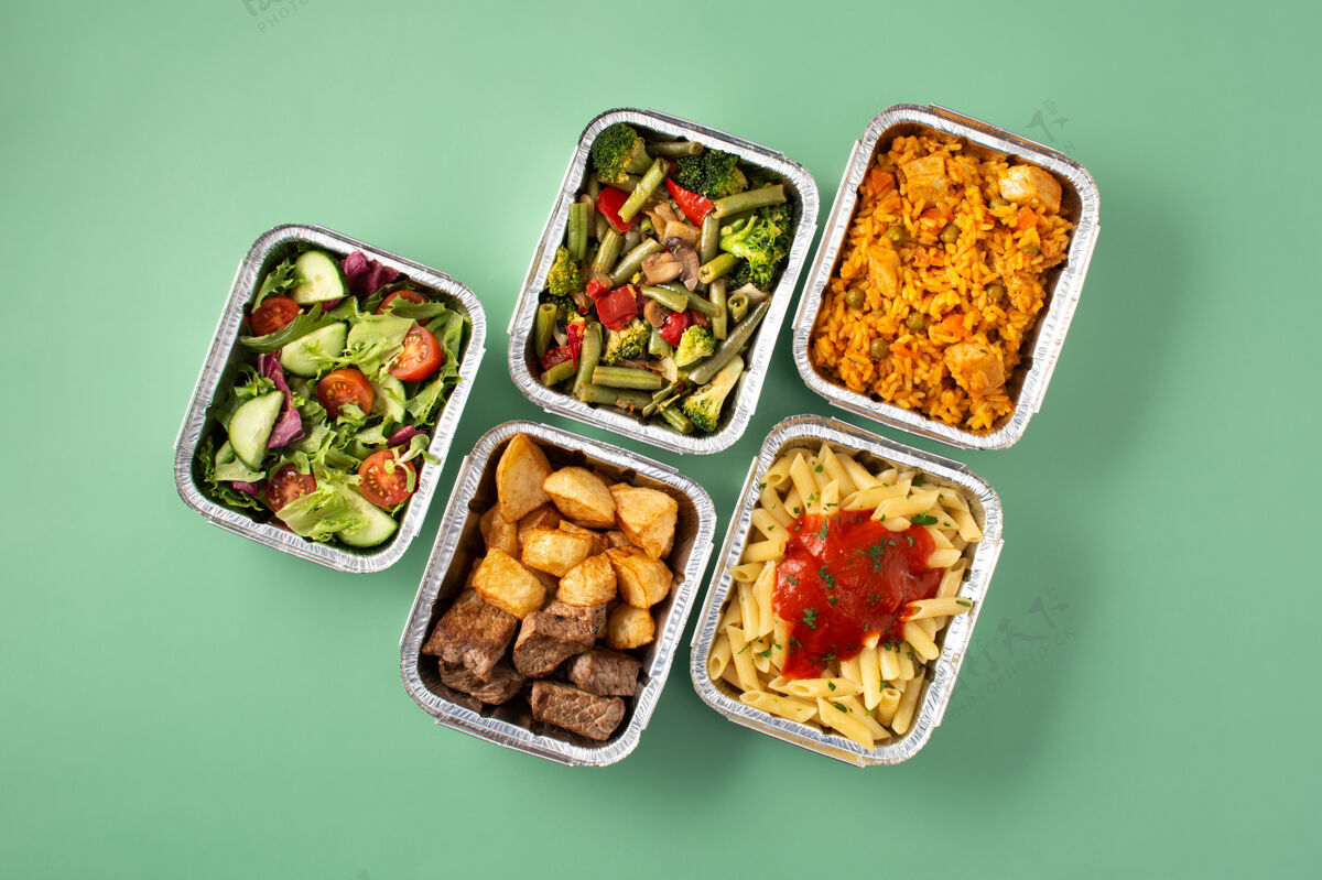 土豆把健康食品放在绿色桌子上的锡箔盒里带走肉类大米薯条