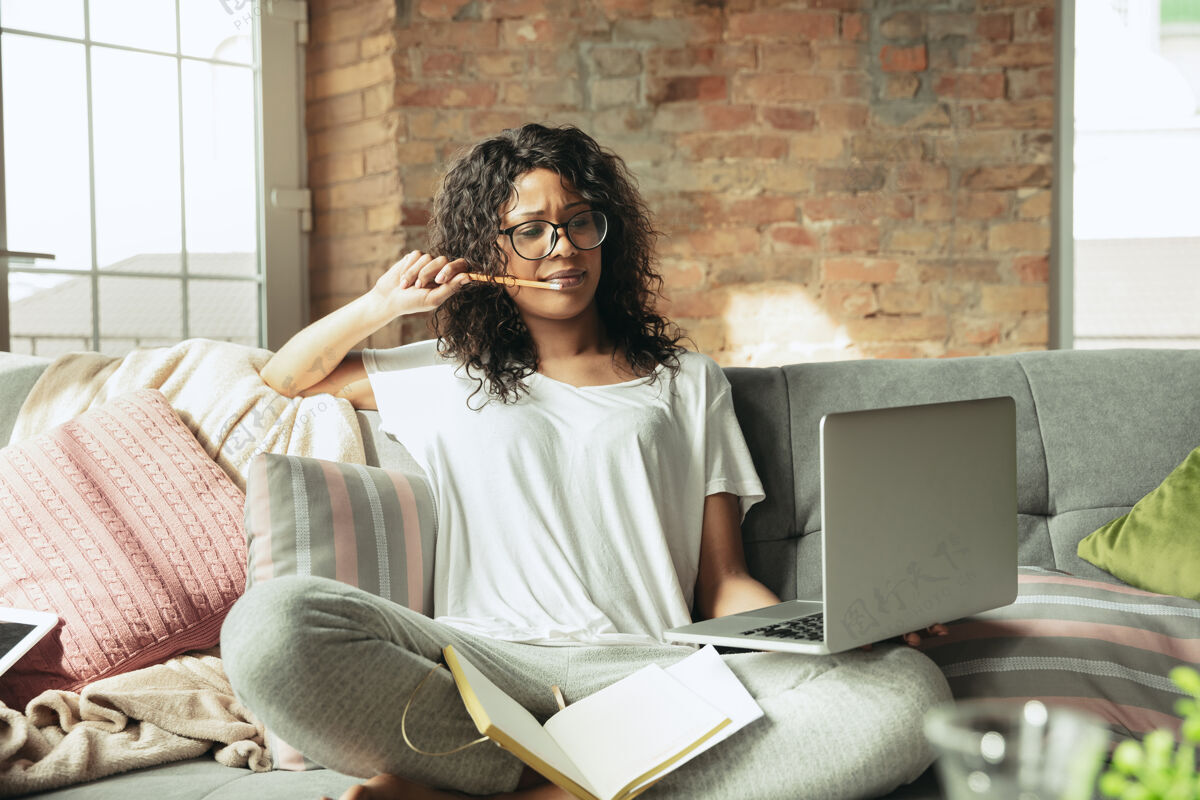 休闲非裔美国女自由职业者在家办公期间一边隔离一边工作房子笔记本电脑电脑