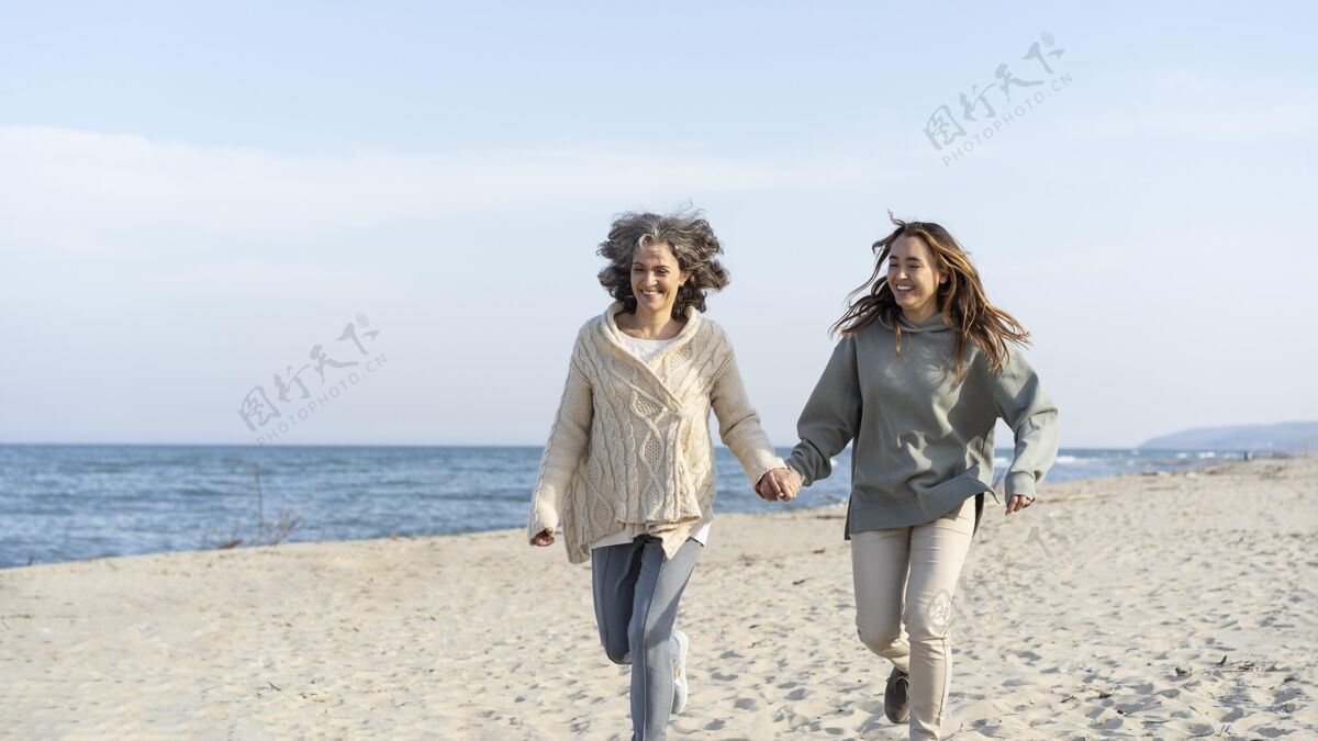 债券妈妈和小女儿一起在沙滩上度过时光水平妈妈海滩