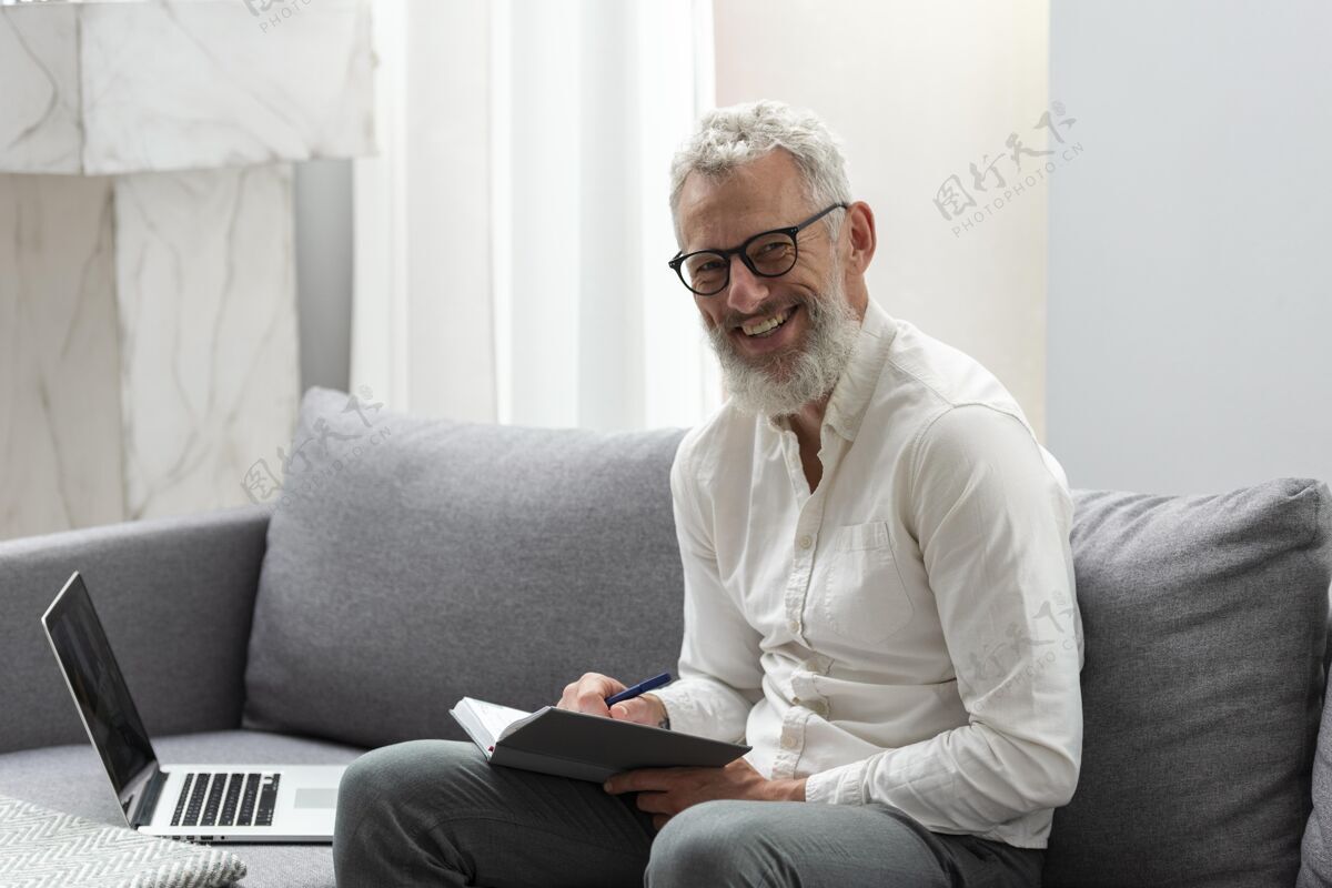 成人在家学习笔记本电脑和做笔记的老人笔记本灰色头发学习