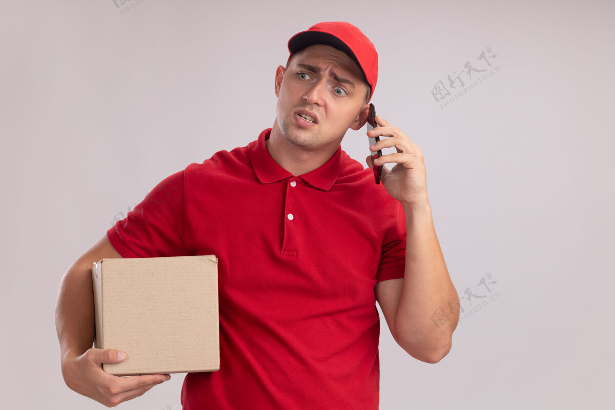 递送困惑地看着身边穿着制服的年轻送货员戴着帽子拿着盒子讲着电话隔着白墙留着复印空间拿着人衣服
