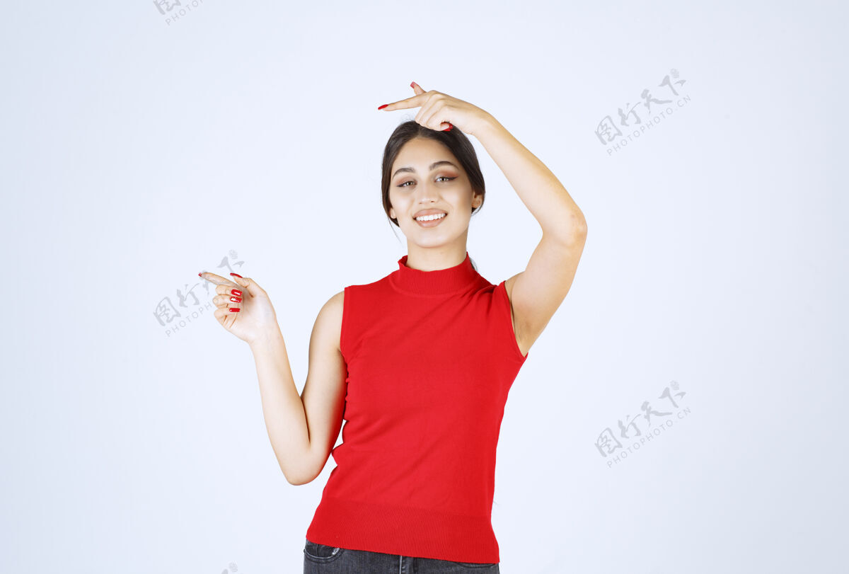 服装穿红衬衫的女孩在展示左边的东西目的地地点女人
