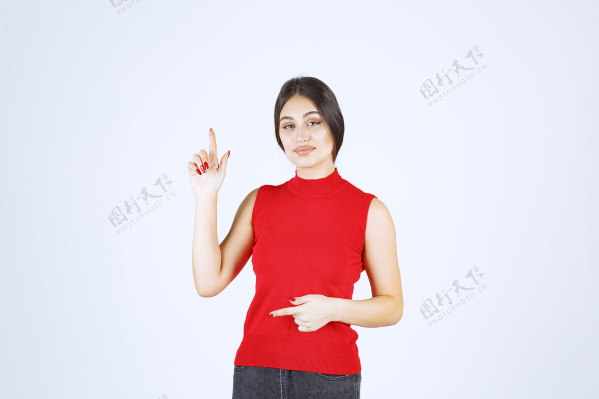 工人穿红衬衫的女孩举手指着上面姿势上装高