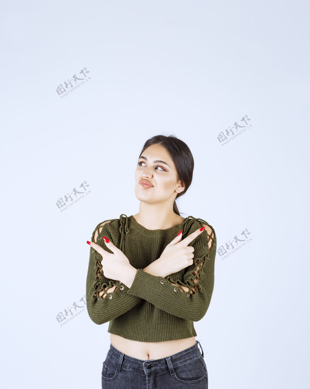 女孩一个年轻的女模特站着 用食指指着别处手指目录模特