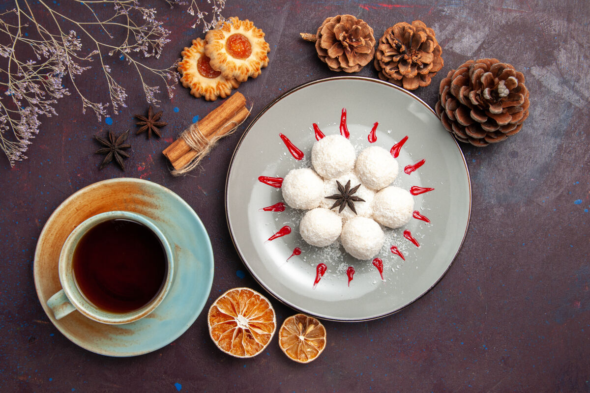 蛋糕俯瞰美味的椰子糖小而圆 在茶杯的深色背景上形成椰子糖茶甜饼饼干茶窗体瓷器