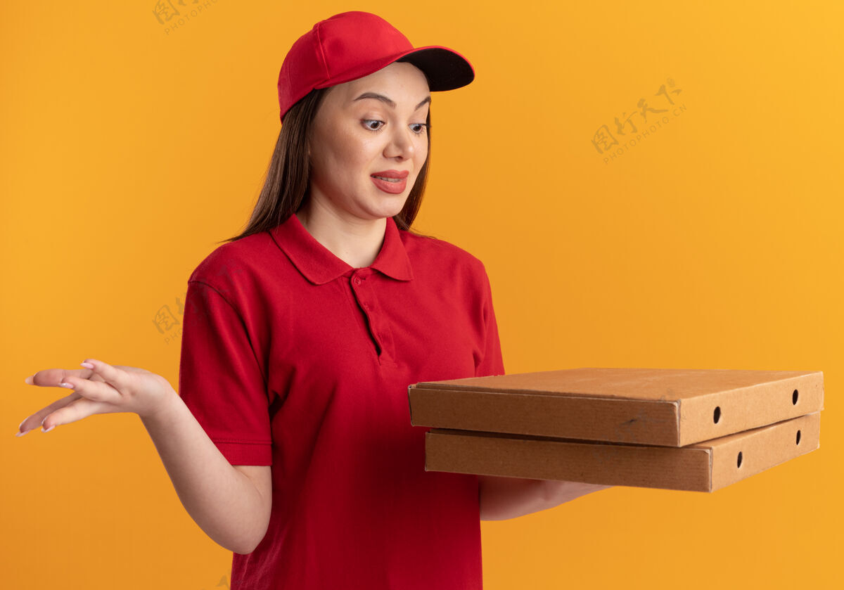 制服穿着制服的漂亮送货员兴奋地抱着比萨饼盒看盒子披萨送货