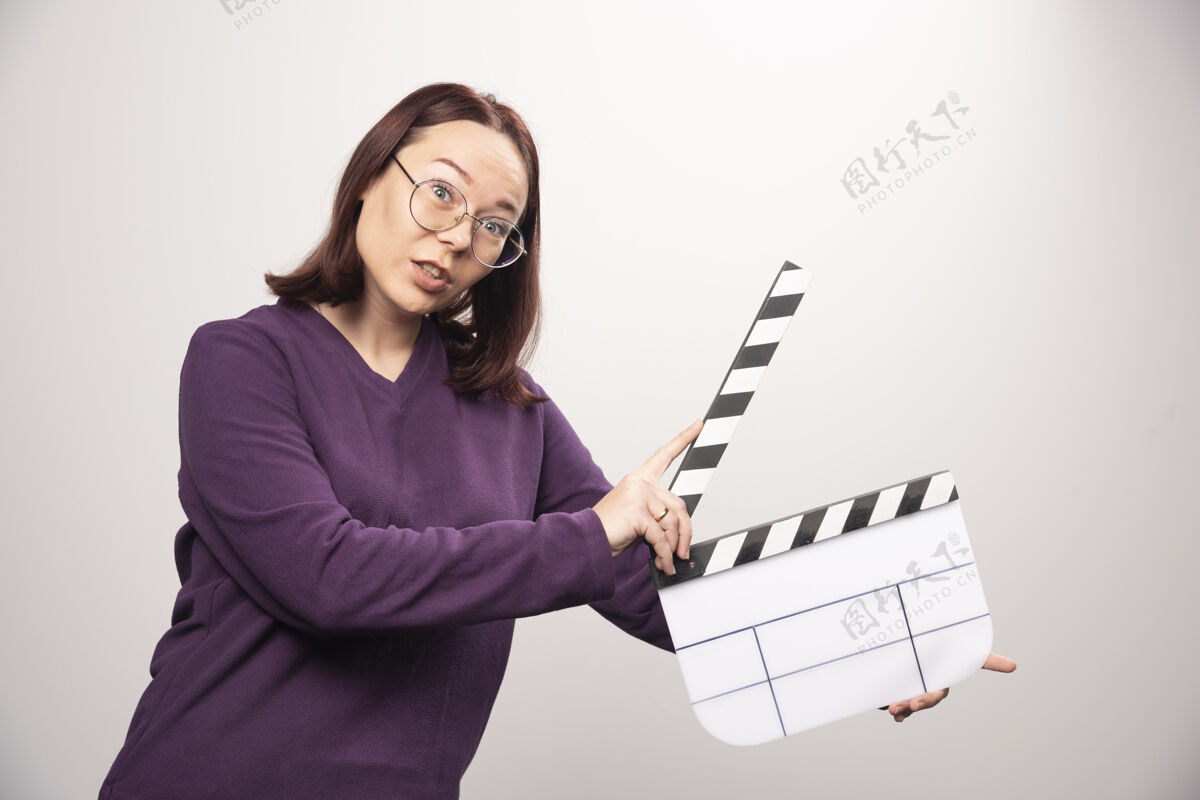 磁带年轻女子拿着一个白色的电影院磁带高质量的照片女士年轻人人类