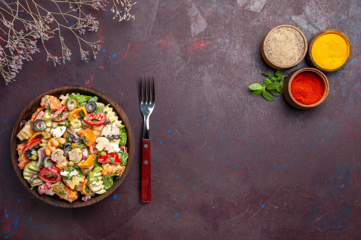 沙拉俯瞰美味的蔬菜沙拉搭配不同调味料的深色背景健康蔬菜减肥午餐沙拉食物饮食美味蔬菜沙拉