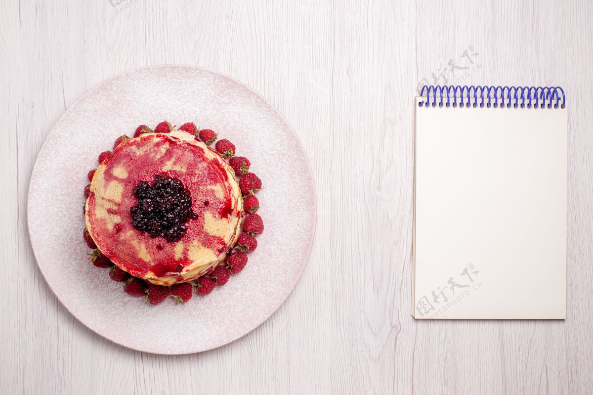 新鲜俯瞰美味的薄煎饼与草莓和果冻的白色背景水果馅饼蛋糕饼干甜浆果草莓果冻浆果